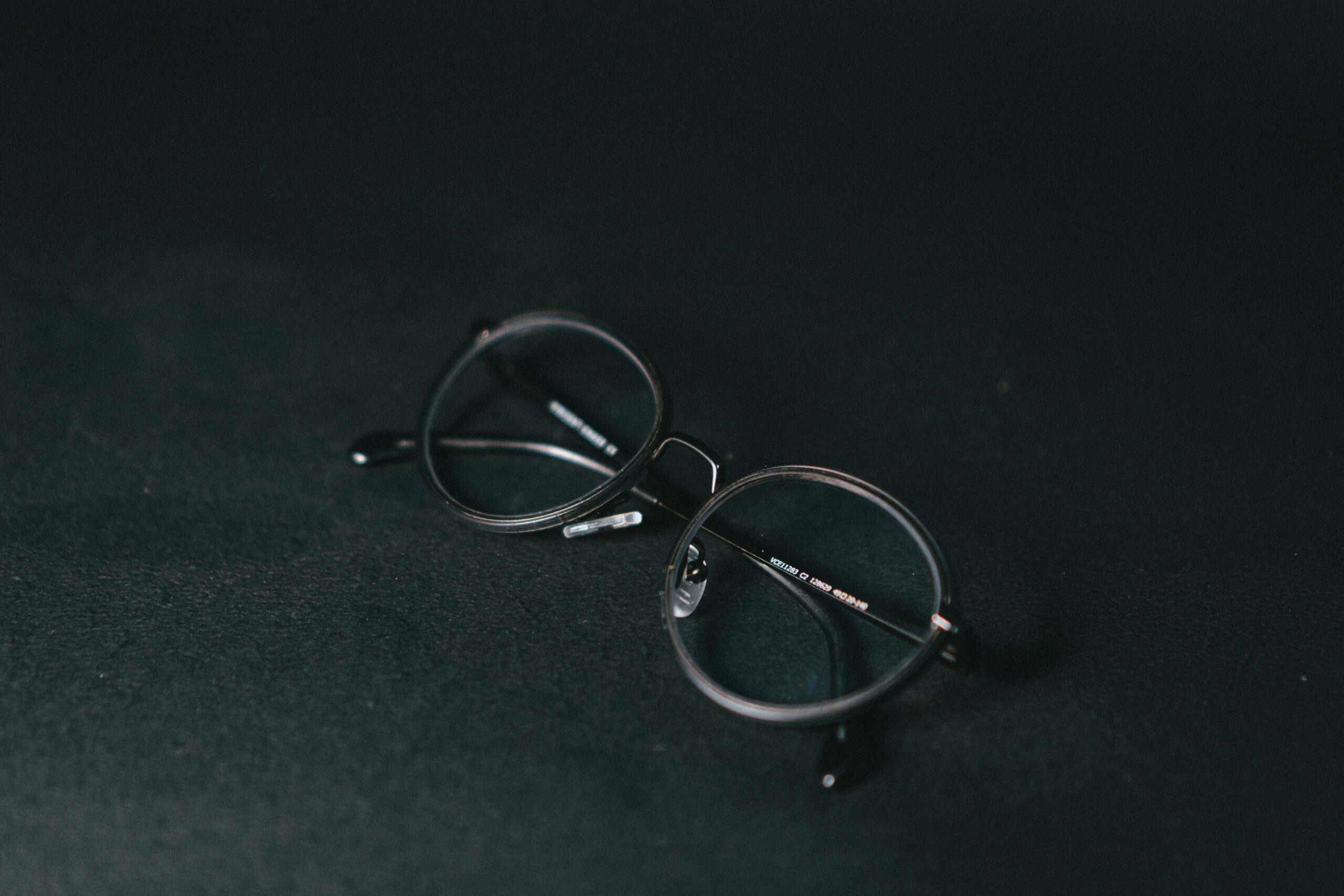 silver framed eyeglasses on black textile